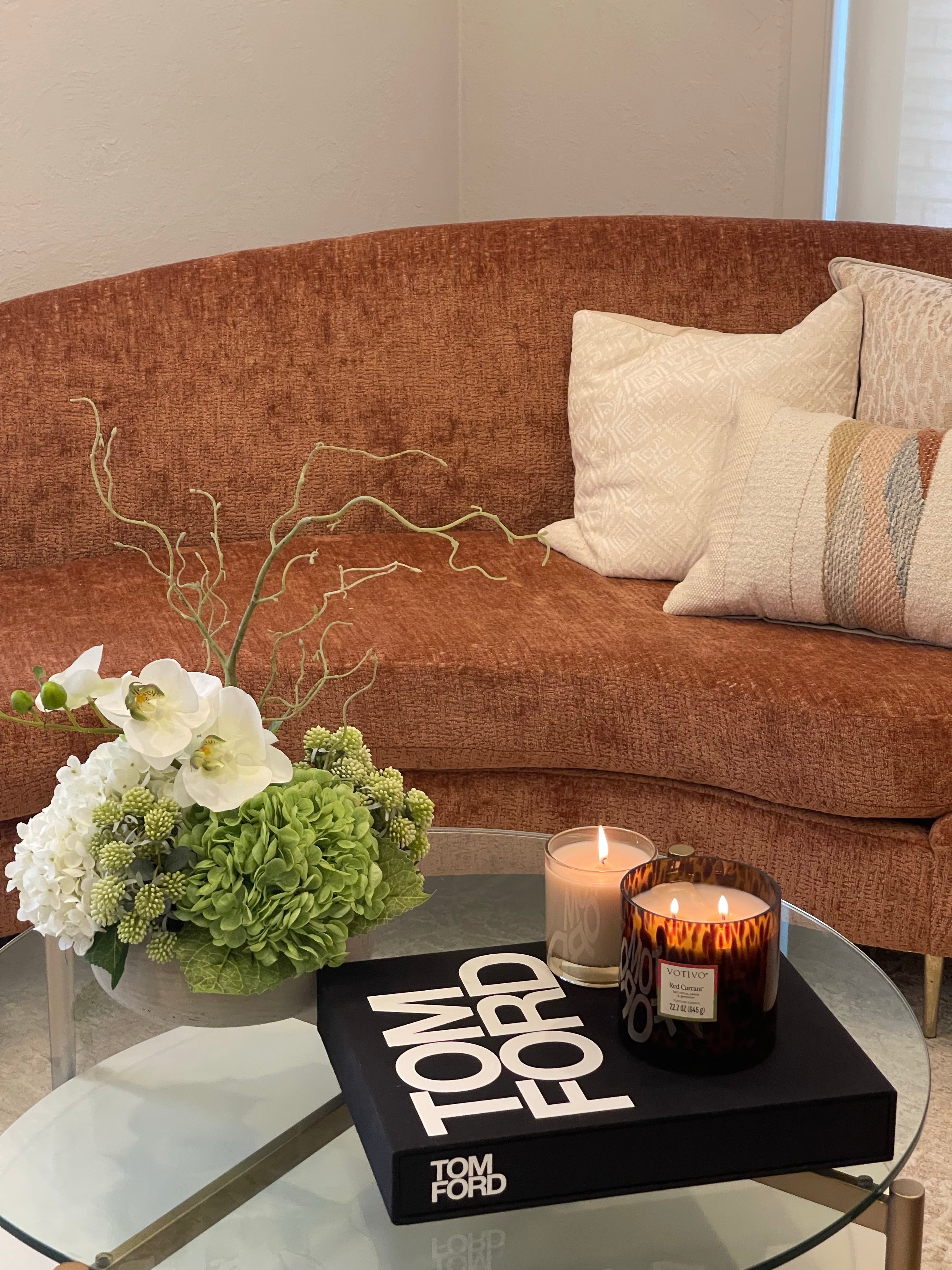 Couchtisch-stilvoll-minimal-dekoriert-mit-Coffee-Table-Book-und-Blumenarrangement.
